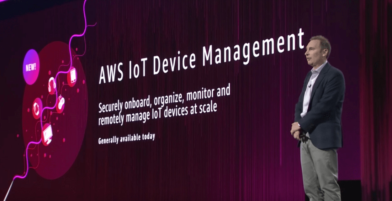 AWS ReInvent conference speaker on stage talking about AWS IoT