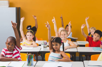 Kids in classroom with their hands up