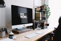 Office desk and book shelf with Do More on the computer screen