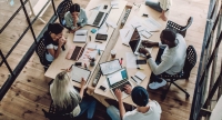 Group of people sitting around meeting desk